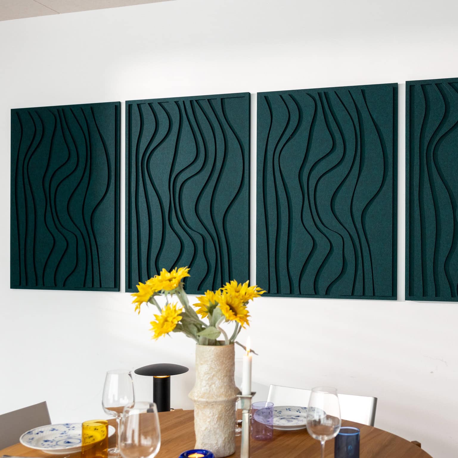 Dark green decorative sound panels with sculptural wave design mounted on wall in modern dining area